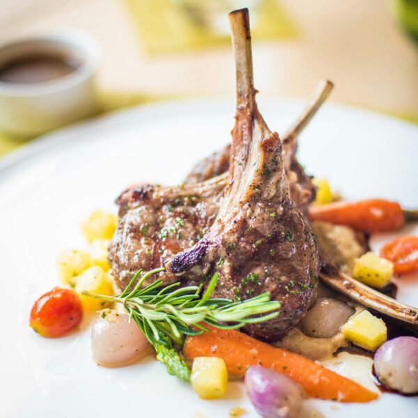 Exquisite plated lamb chops with colorful vegetables, showcasing fine gastronomy.